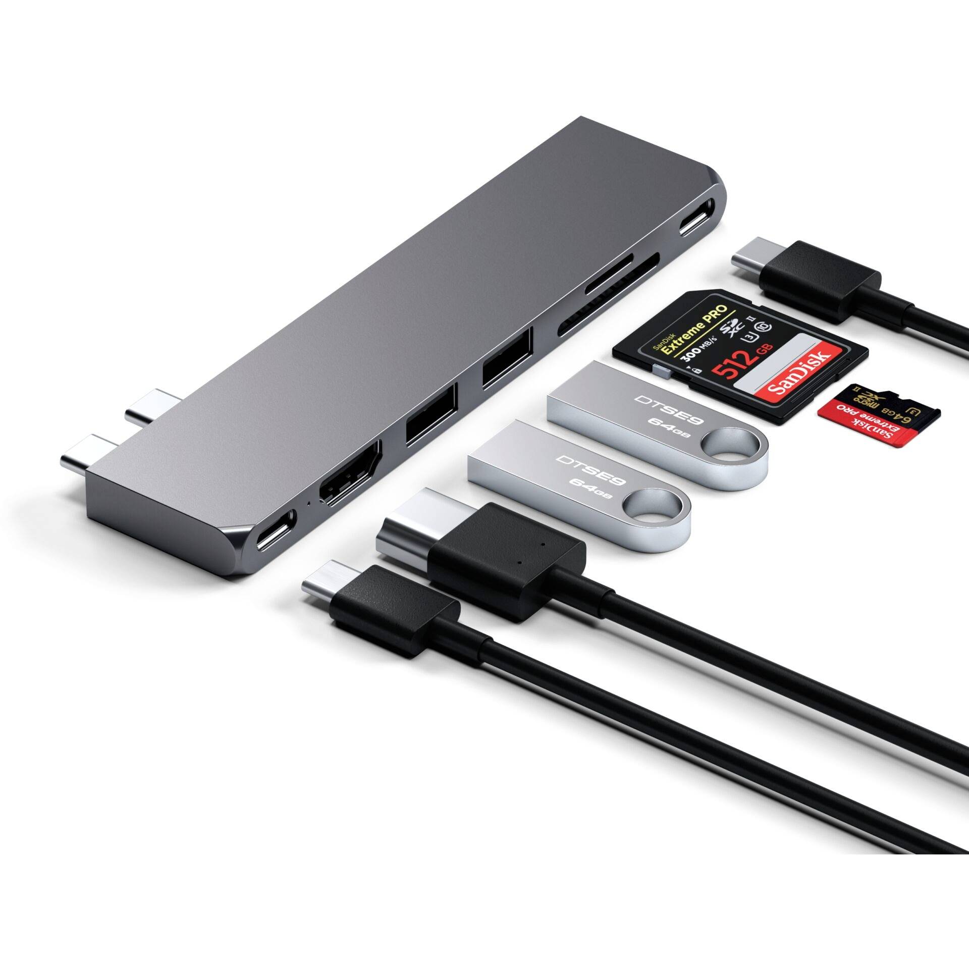 Ein grauer USB-C-Hub mit mehreren Anschlüssen, darunter HDMI, USB-A, USB-C und Steckplätze für SD-Karten. Umgeben von Kabeln und USB-Sticks.