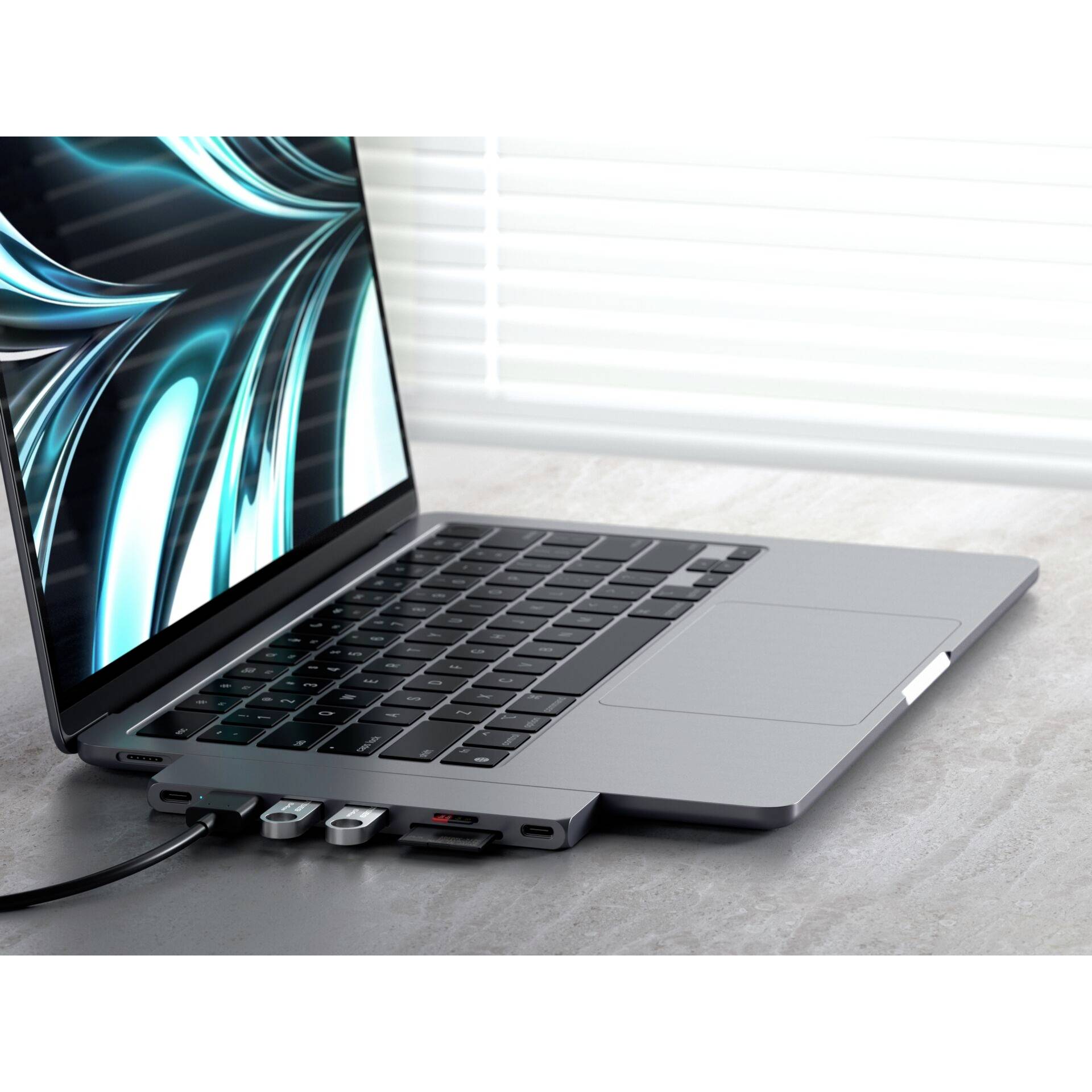 Ein geöffneter Laptop mit mehreren angeschlossenen USB-Geräten auf einem Tisch. Ein Fenster im Hintergrund lässt Licht herein.