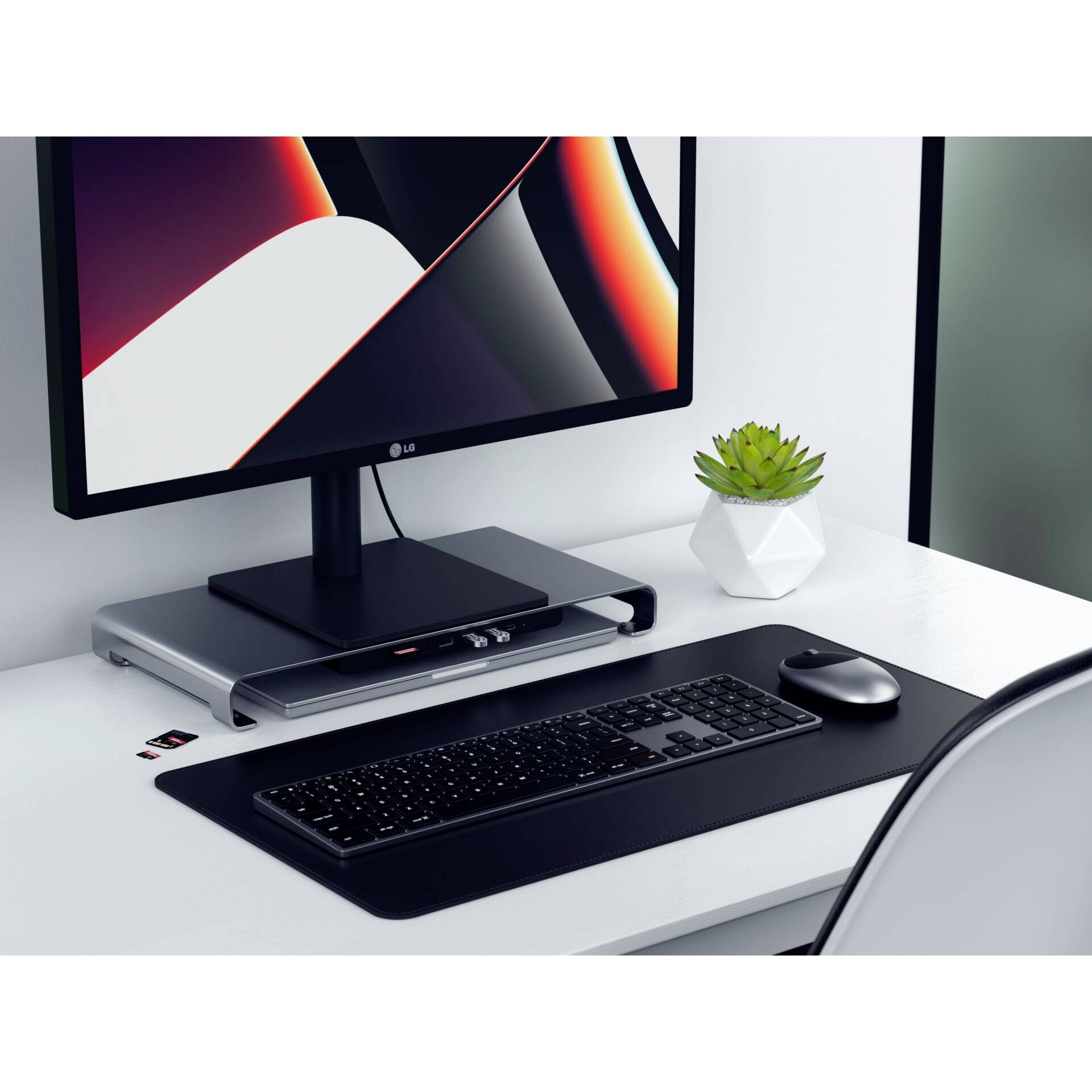 Eleganter, moderner Arbeitsplatz mit Monitor, Tastatur, Maus und kleiner Pflanze auf einem weißen Tisch. Minimalistisches Design.