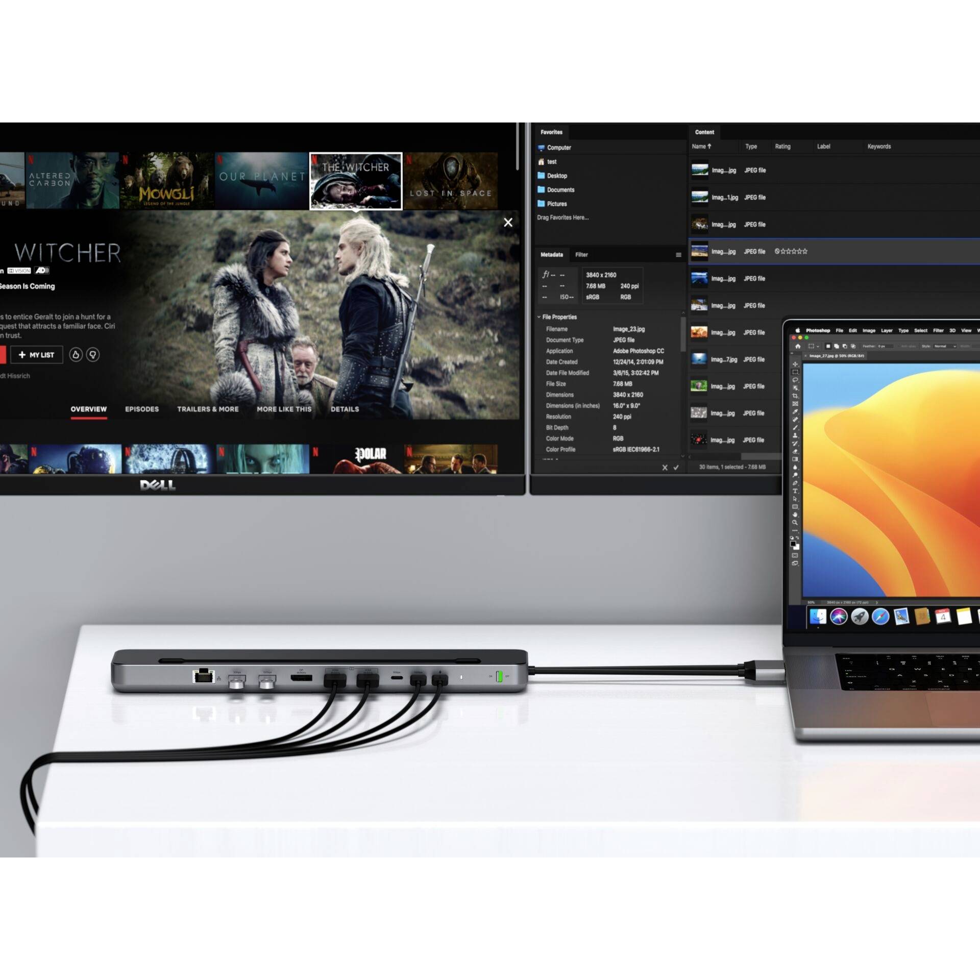 Laptop verbunden mit Dockingstation, die mehrere Kabel an Monitor anschließt. Monitor zeigt Bild einer TV-Serie und Dateimanager.