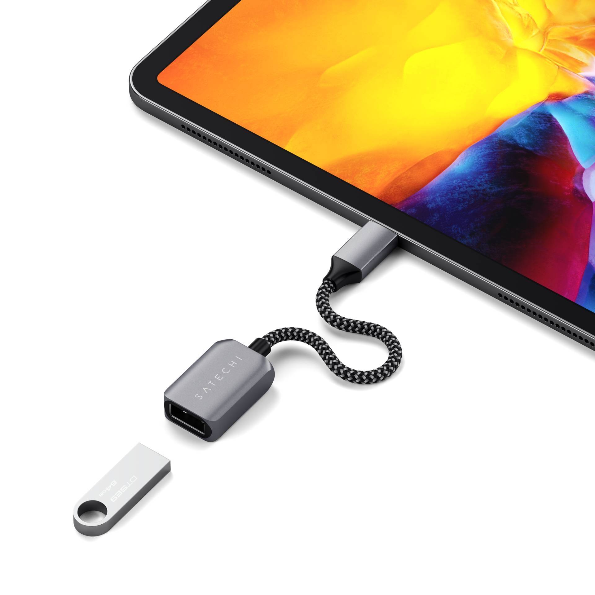 Ein Tablet mit leuchtendem Bildschirm ist mit einem USB-C-Adapter verbunden. Daneben liegt ein kleiner USB-Stick.