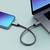 Smartphone und Laptop verbunden durch ein geflochtenes Kabel, das die Datenübertragung zwischen den Geräten ermöglicht.