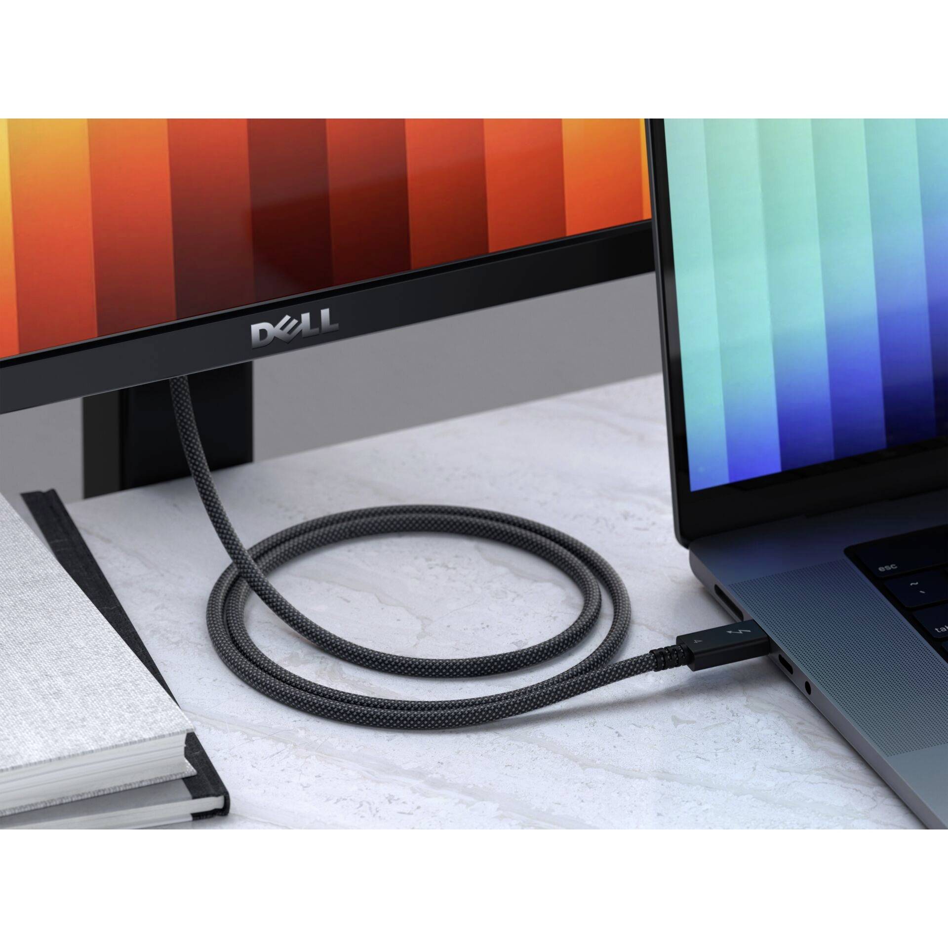 Ein Büro-Schreibtisch mit einem Laptop und Monitor, die über ein Kabel verbunden sind. Der Monitor zeigt bunte vertikale Streifen.