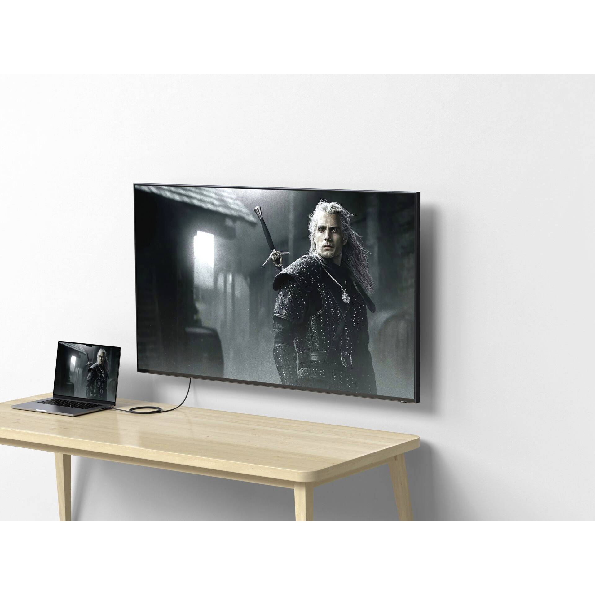 Ein Laptop ist mit einem Fernseher verbunden, der eine Filmszene mit einem mittelalterlichen Krieger in dunkler Kleidung zeigt.