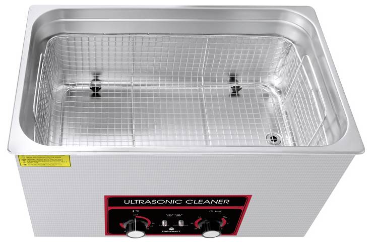 Ultraschallreiniger mit Metallkorb. Zwei Drehknöpfe an der Vorderseite zur Einstellung von Zeit und Temperatur.