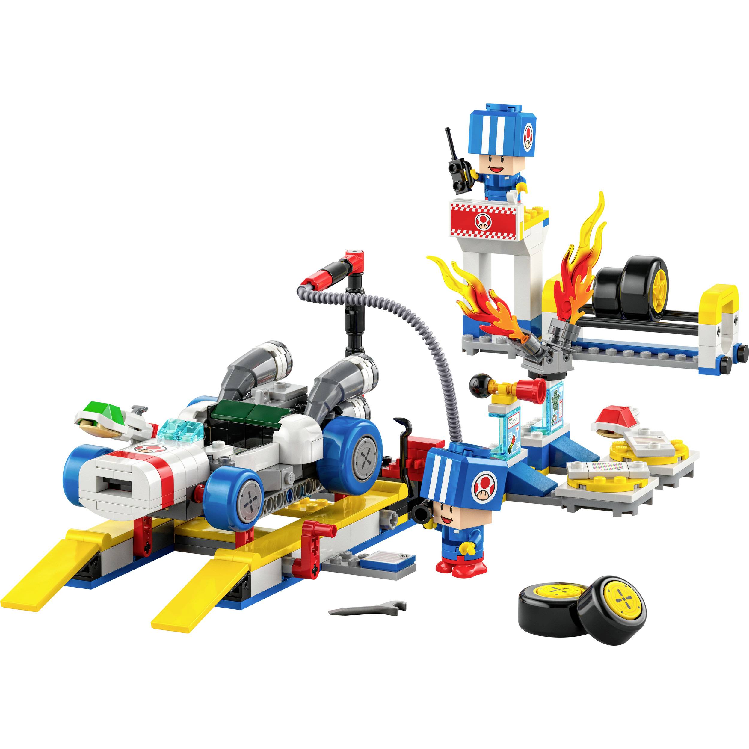 Ein buntes Spielzeug-Set zeigt eine Werkstatt mit Rennauto, Spielfigur in Mechaniker-Outfit, Flammen, Autoreifen und Werkzeugen.