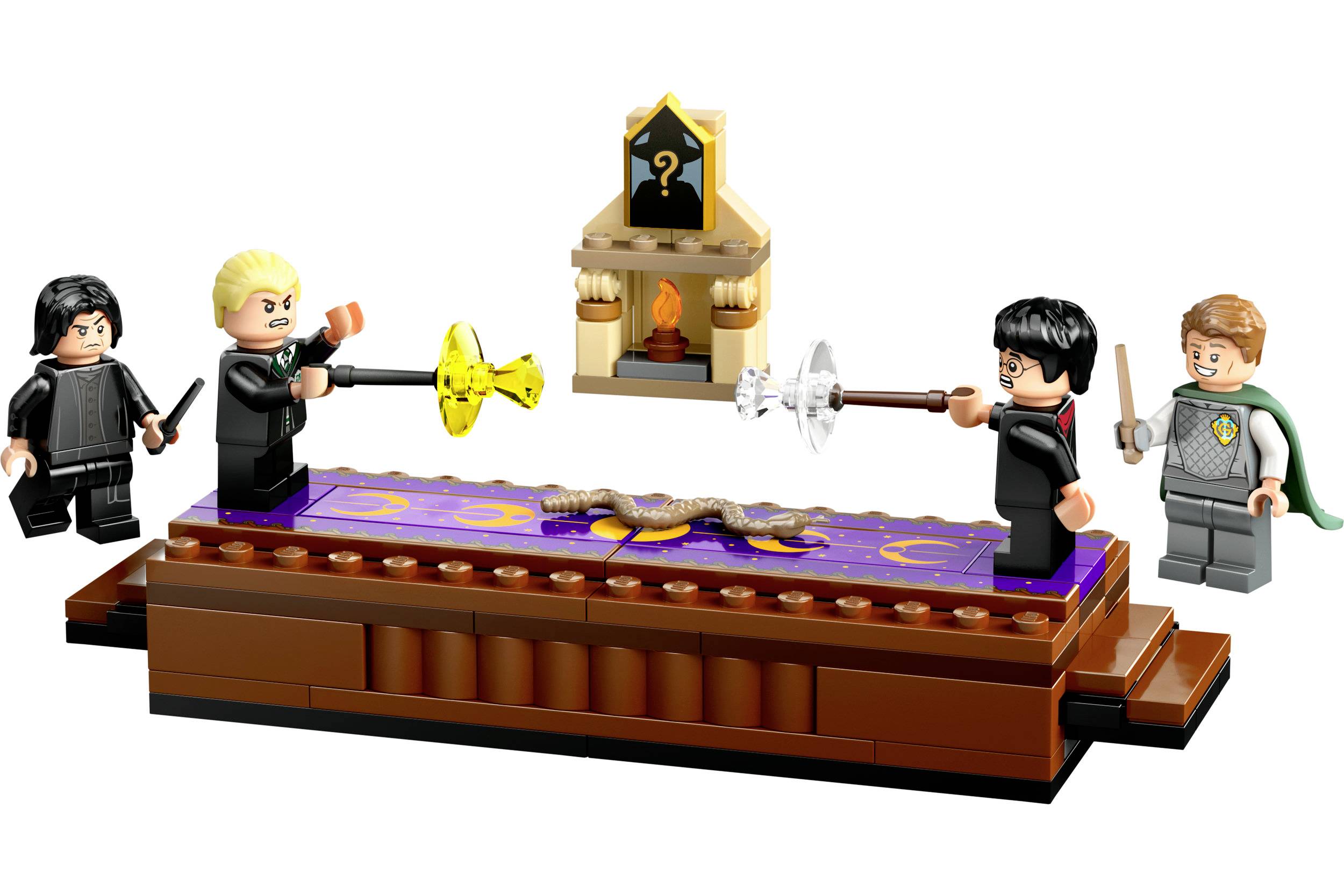 Vier Lego-Figuren mit Zauberstäben stehen auf einer Bühne, die eine Szene aus Harry Potter darstellt. Im Hintergrund ein Kamin.