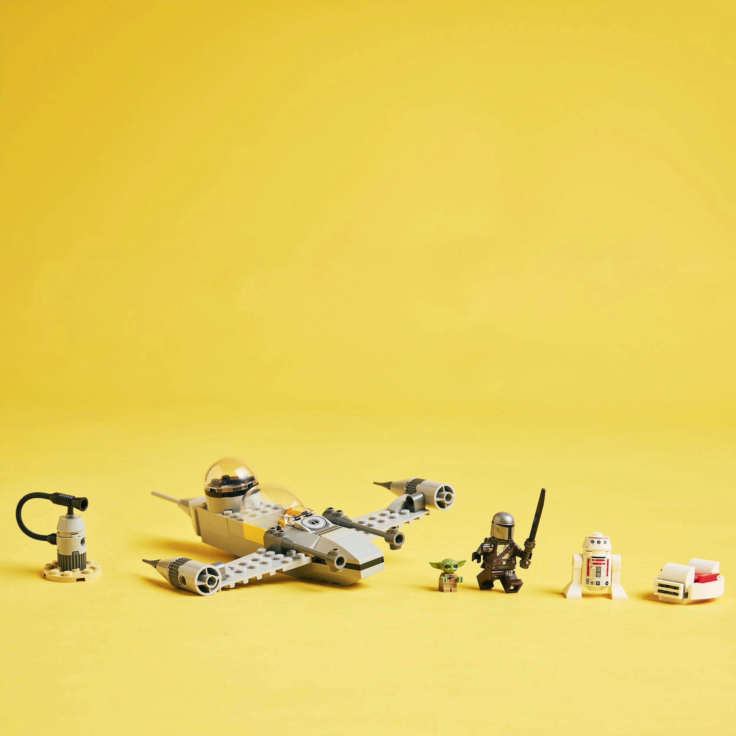 Spielzeug-Raumschiff mit Figuren und Zubehör vor gelbem Hintergrund, einschließlich kleiner Figuren eines Kriegers, Roboters und grüner Kreatur.