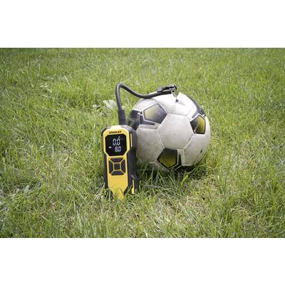 Ein Fußball liegt auf Gras neben einem gelben digitalen Manometer, das den Druck bei 0,0 anzeigt.
