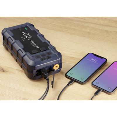 Ein tragbares Ladegerät lädt zwei Smartphones auf. Das Display zeigt '100%' an, was den vollen Ladezustand des Geräts anzeigt.