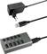 Ein USB-Hub mit vier Anschlüssen, zwei blaue und zwei schwarze, daneben ein Netzteil und ein USB-Kabel zur Stromversorgung und Verbindung.