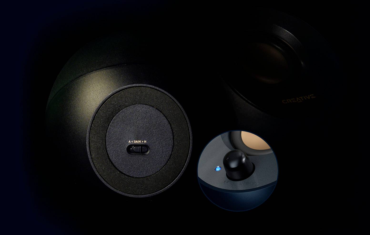 Zwei schwarze Lautsprecher, mit Nahaufnahme eines Schalters und einer blauen Kontrollleuchte. Erweiterte Klangeinstellungen sind sichtbar.
