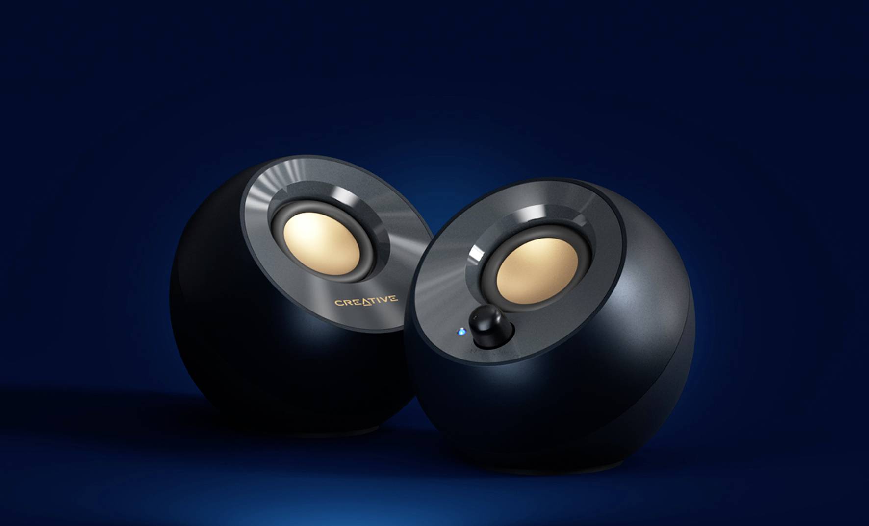 Zwei runde schwarze Lautsprecher auf blauem Hintergrund, einer mit einem kleinen blauen Licht.