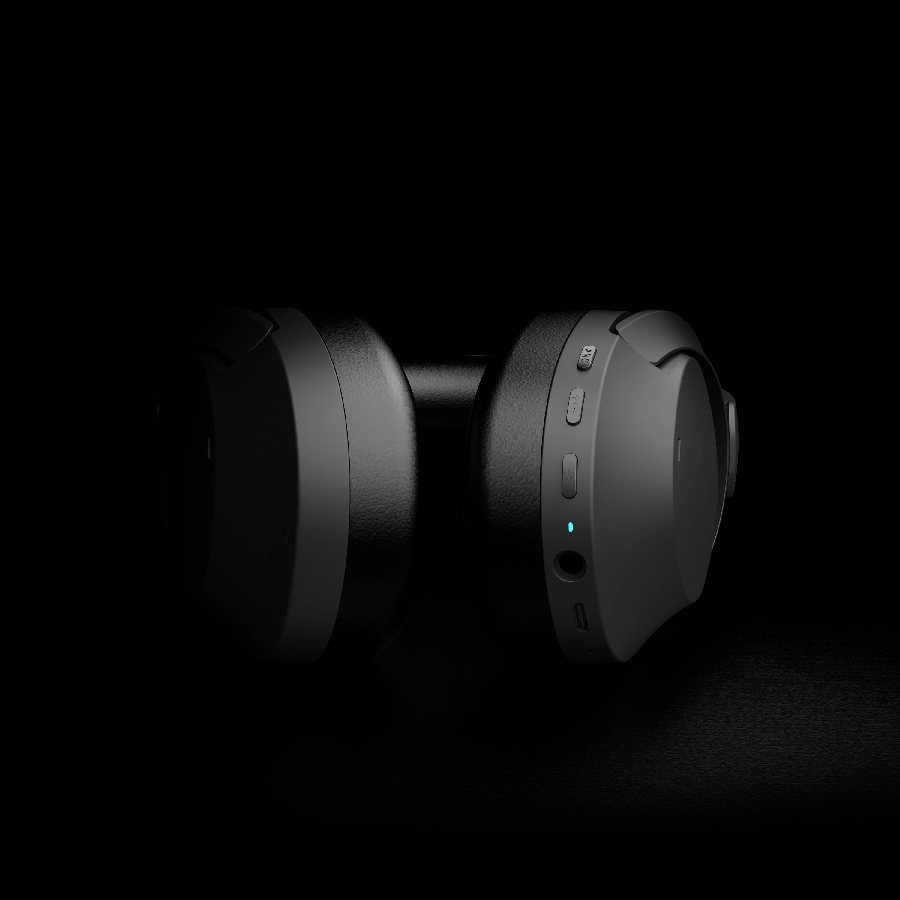 Schwarzer kabelloser Kopfhörer mit beleuchtetem Steuerknopf auf dunklem Hintergrund, symbolisierend moderne Audiotechnologie.