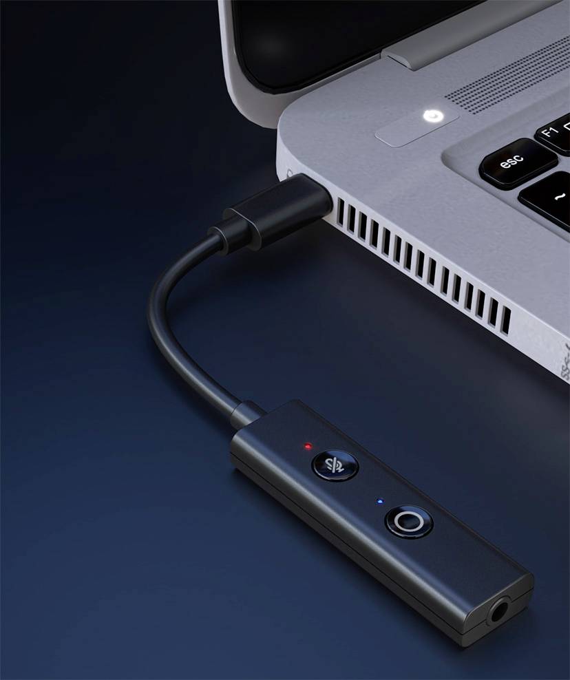 Externe Soundkarte mit USB-Anschluss, verbunden mit einem Laptop. Zeigt Tasten für Lautstärkeregler und Mikrofonsteuerung.