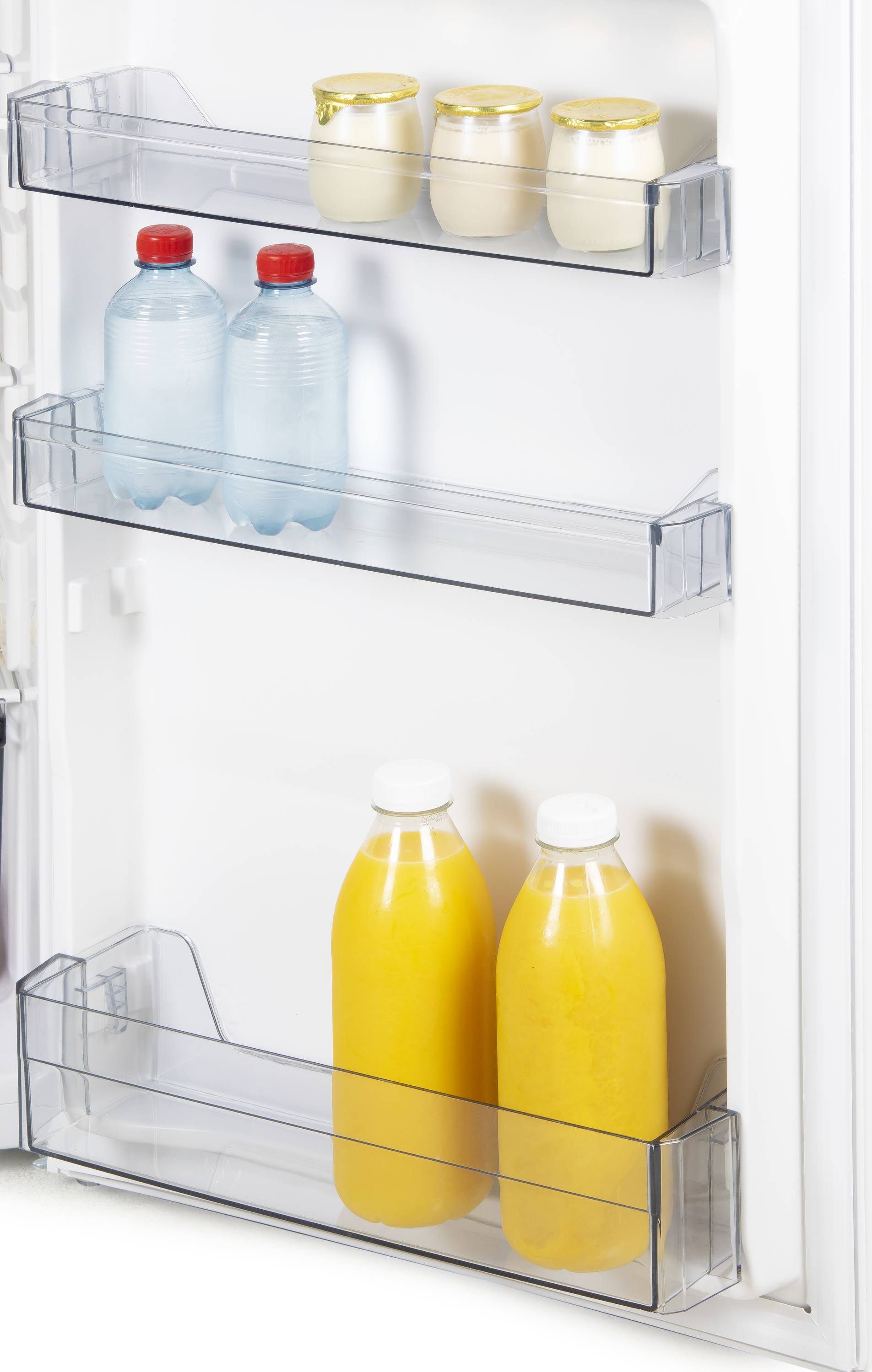 Offene Kühlschranktür mit Flaschen und Gläsern in den Fächern: Zwei Plastikflaschen Wasser oben, drei Joghurtgläser mittig, zwei Orangensaftflaschen unten.