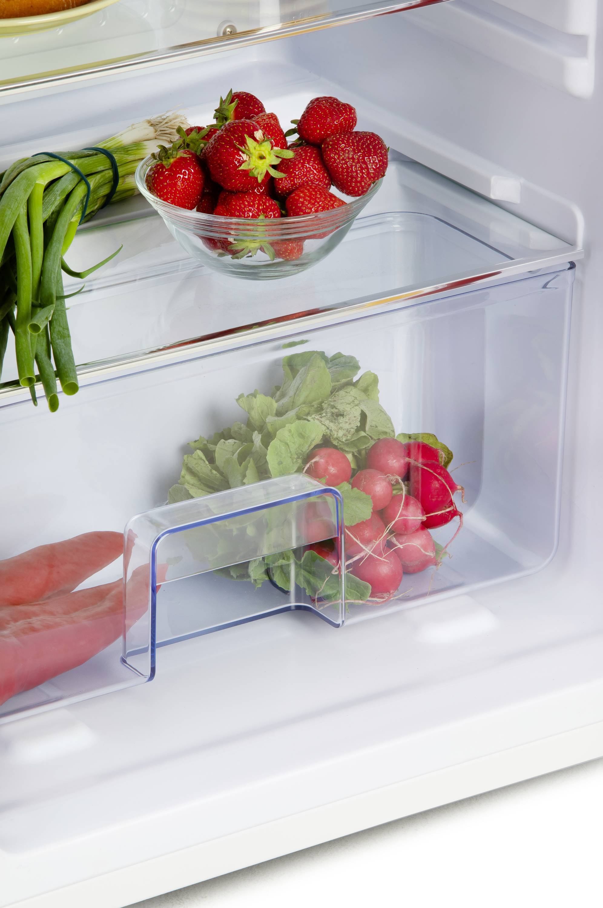 Ein offener Kühlschrank zeigt eine Schale mit Erdbeeren, Frühlingszwiebeln und ein Fach mit Radieschen.