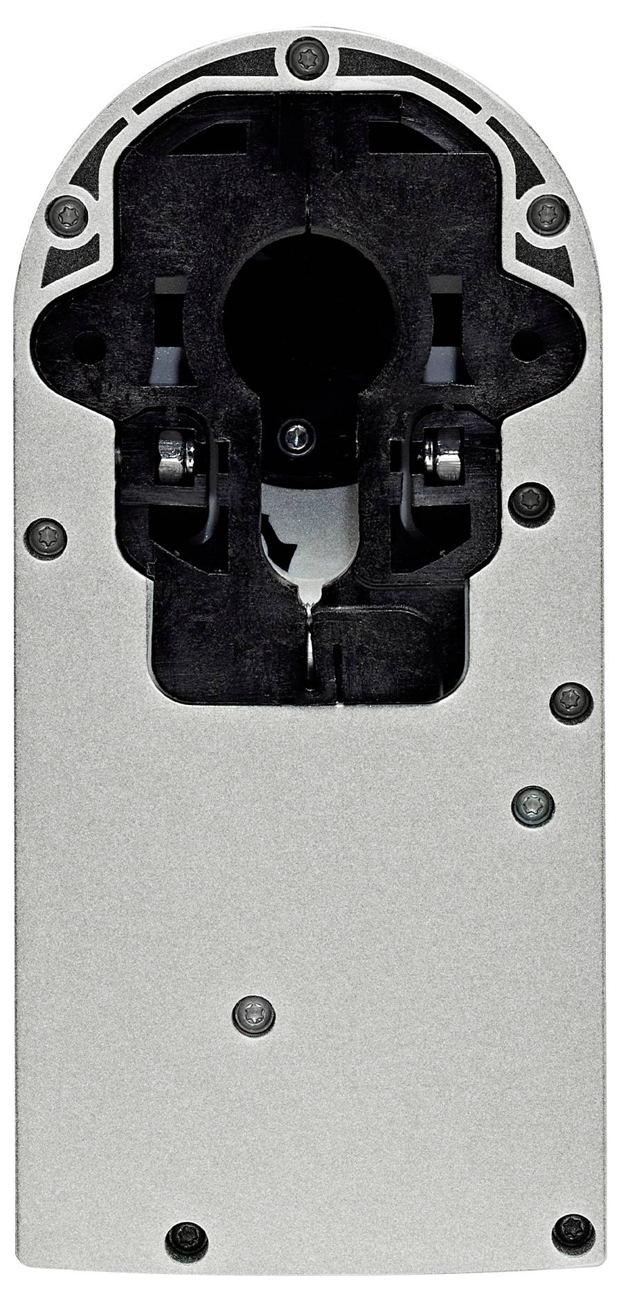 Rückseite einer mechanischen Vorrichtung mit sichtbaren Schrauben und dunklen Aussparungen, möglicherweise ein Teil eines Motors oder Werkzeugs.