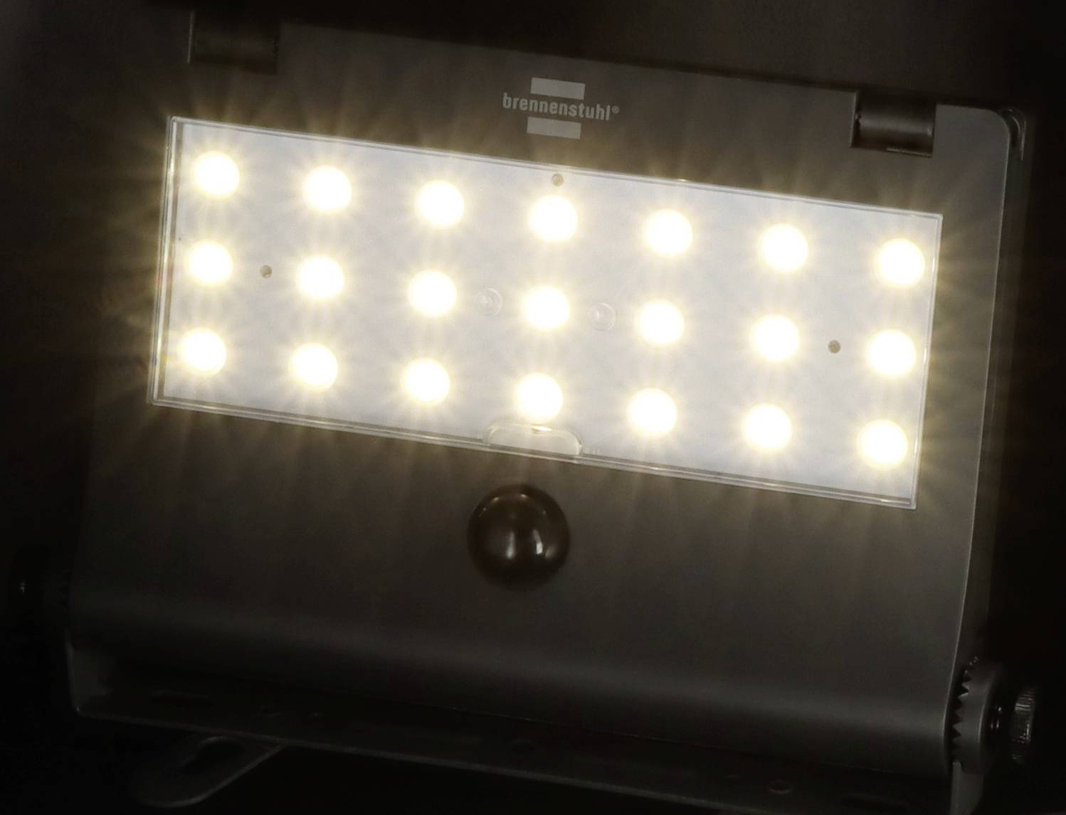 'LED-Strahler mit Bewegungsmelder' auf schwarzem Hintergrund. 24 leuchtende weiße LEDs. Marke 'brennenstuhl' oben sichtbar.