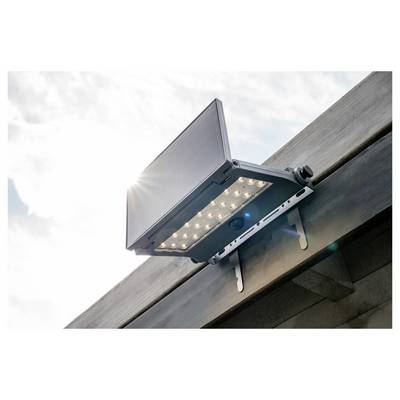 Außen angebrachter, an einer Dachrinne befestigter LED-Flutlichtstrahler, der im Winkel nach unten gegen einen hellen Himmel gerichtet ist.