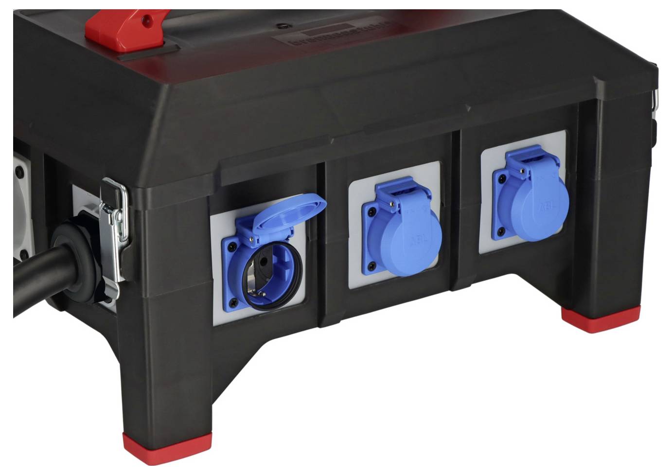 Schwarze tragbare Stromverteilungsbox mit drei blauabgedeckten Steckdosen und einem roten Schalter, dargestellt auf weißem Hintergrund.