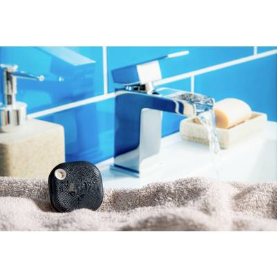 Ein schwarzes Gerät liegt auf einem Handtuch neben einem modernen Wasserhahn im Bad. Im Hintergrund ein Seifenspender und Seife.