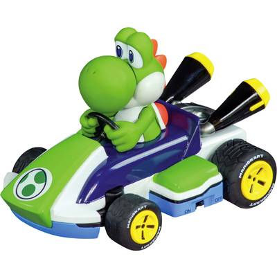 Ein grüner, cartoonartiger Drache fährt ein farbenfrohes Gokart. Das Fahrzeug hat große Auspuffrohre und gelbe Reifen.