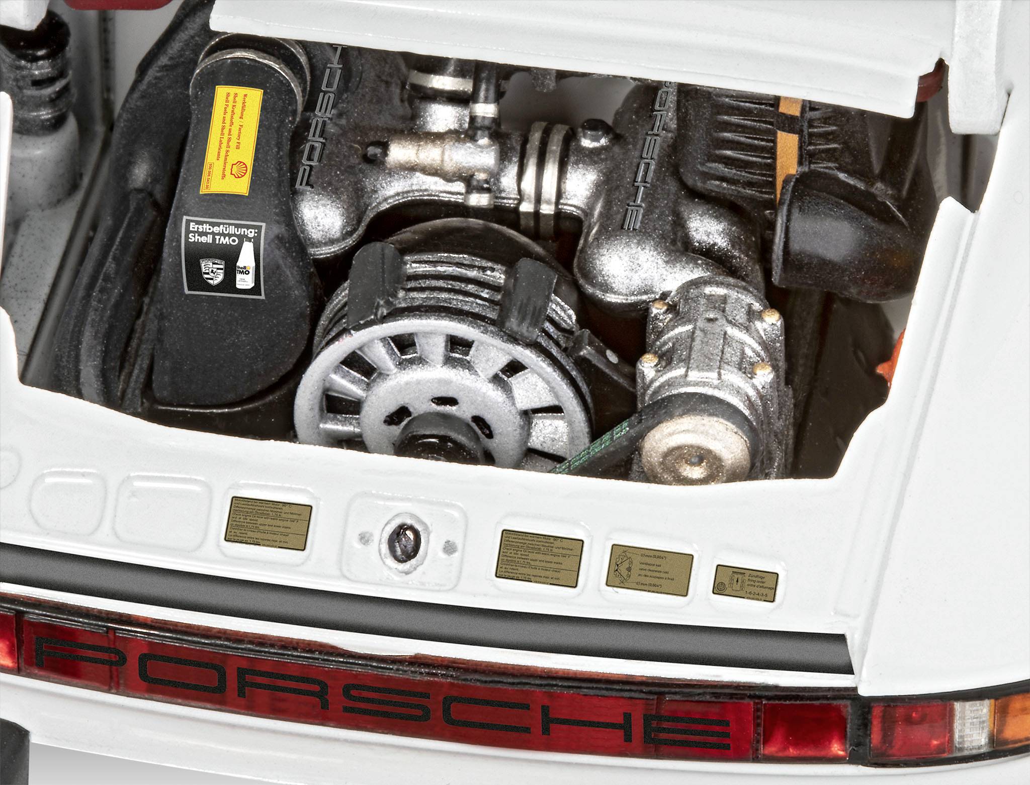 Ein Modell eines Porsche-Motors, offen präsentiert, zeigt Details wie Riemenscheiben und Zylinder. Das Porsche-Logo ist sichtbar.