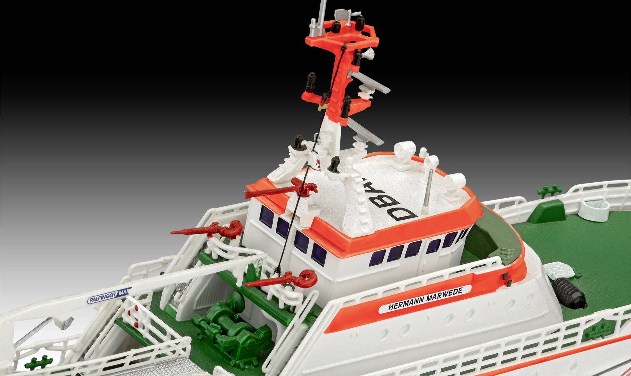 Ein Modell eines Seenotrettungskreuzers mit orangefarbenen und weißen Details, Antennen und Rettungsausrüstung auf Deck.