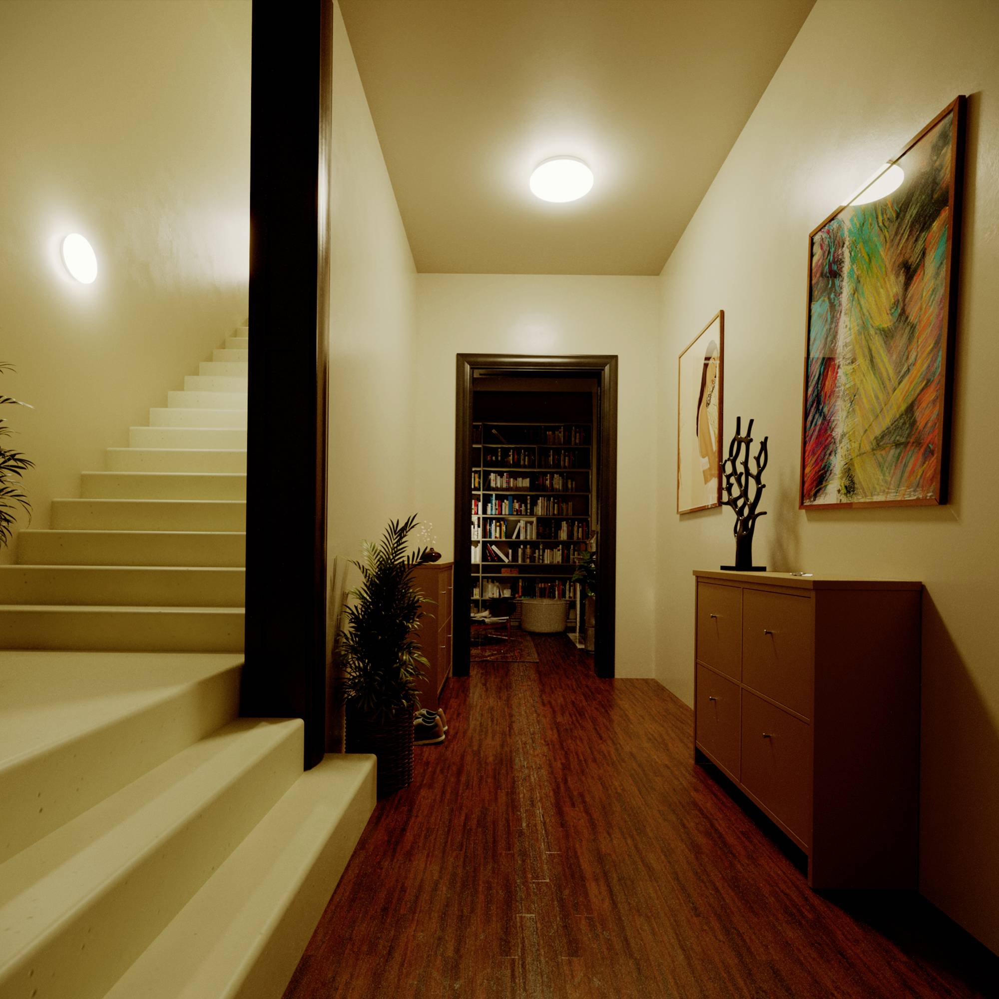 Ein modern gestalteter Flur mit Holzfußboden führt zu einem Raum mit Büchern. An der Wand hängen bunte Kunstwerke.