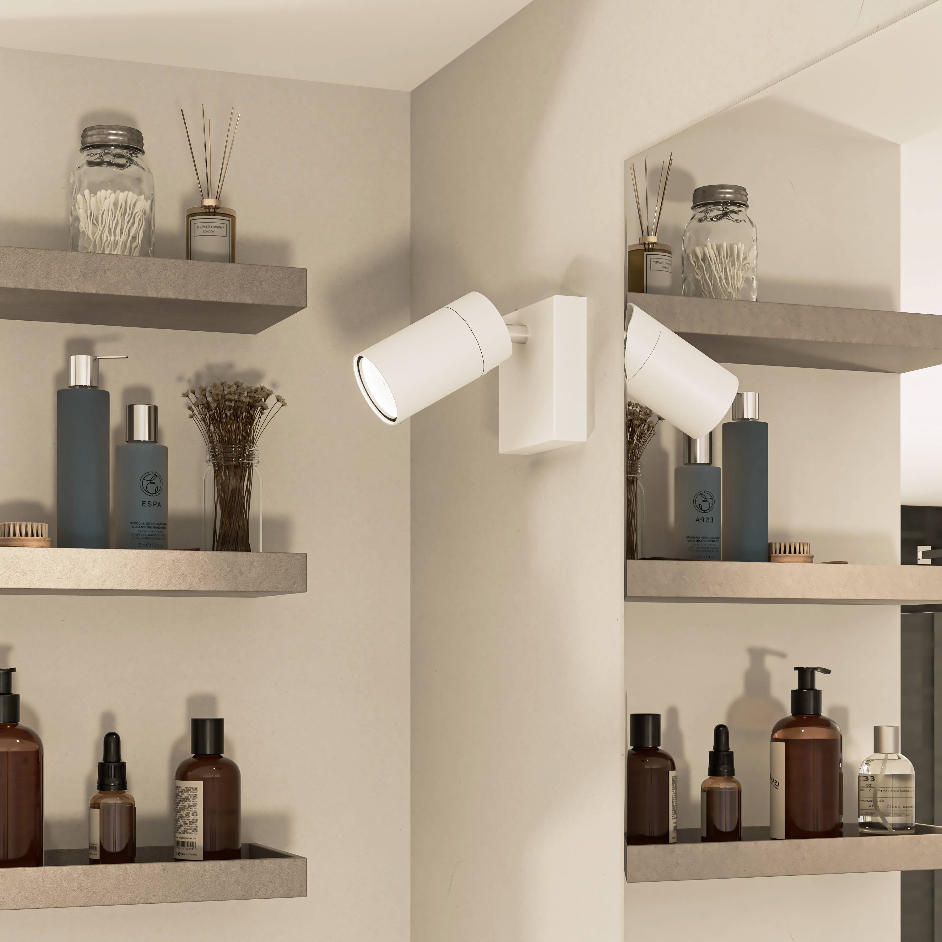 Regale mit einer Auswahl an Pflegeprodukten und Kosmetika, beleuchtet von einer weißen Wandleuchte, in einem modernen Badezimmer.