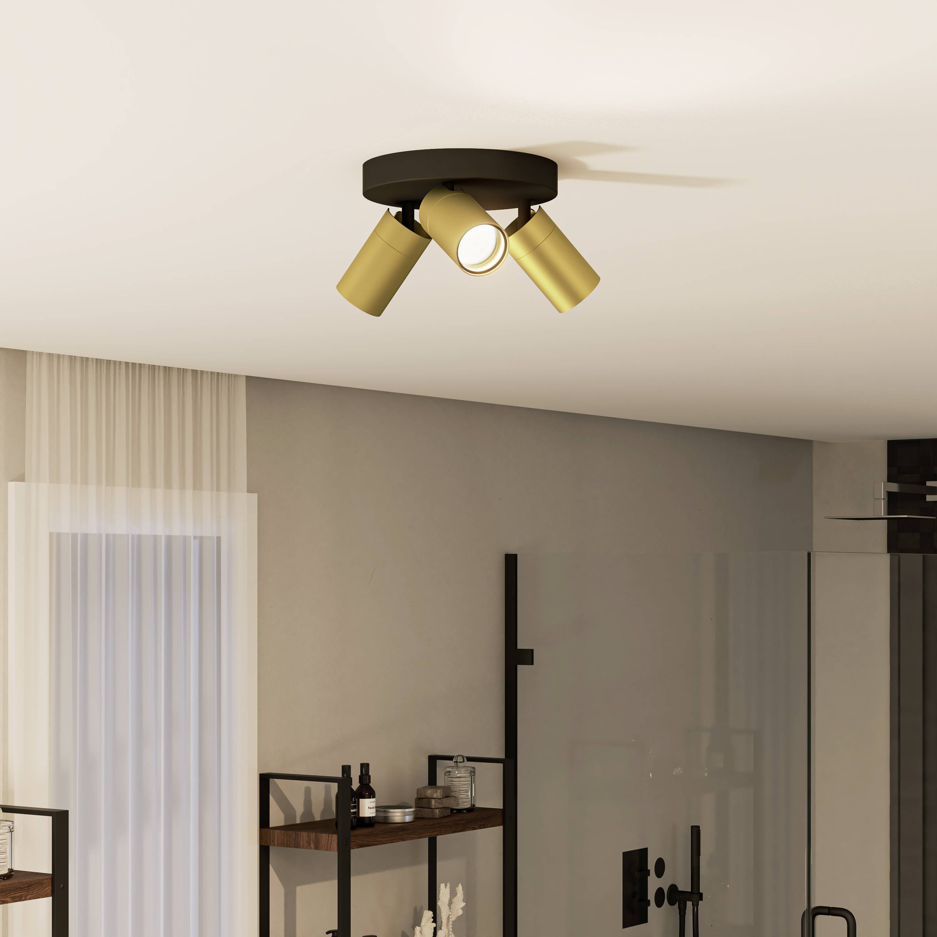 Ein Wohnzimmer mit Deckenstrahler in moderner, goldener Ausführung. Der Raum hat ein großes Fenster mit transparenten Vorhängen.
