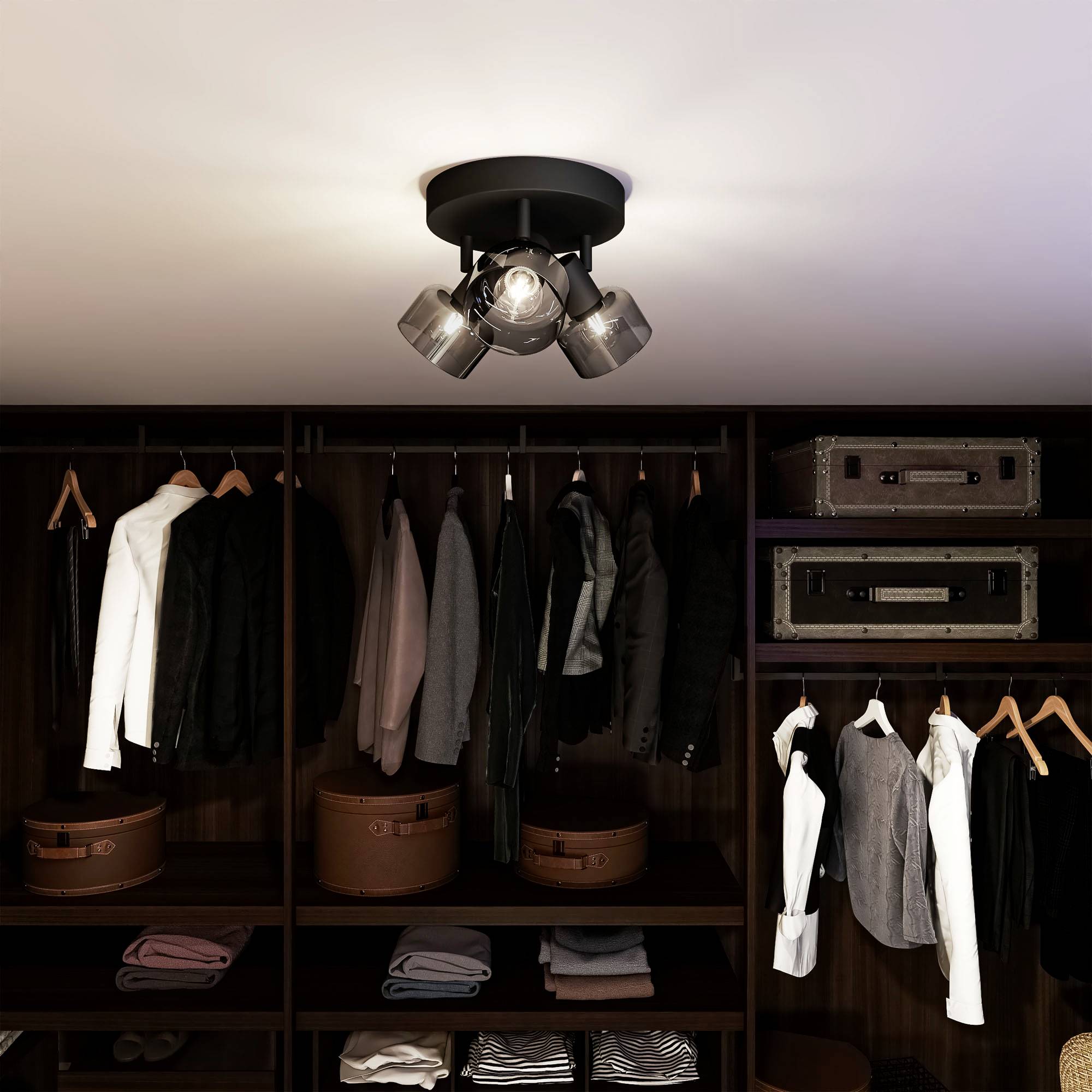 Ein Kleiderschrank mit hängenden Anzügen und Hemden, darunter Regalbretter mit ordentlich gefalteten Pullovern und Hüten.