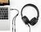 Ein Laptop mit angeschlossenen Kopfhörern über ein Audiokabel. Der Laptop steht auf einem weißen Hintergrund, linke obere Ecke.