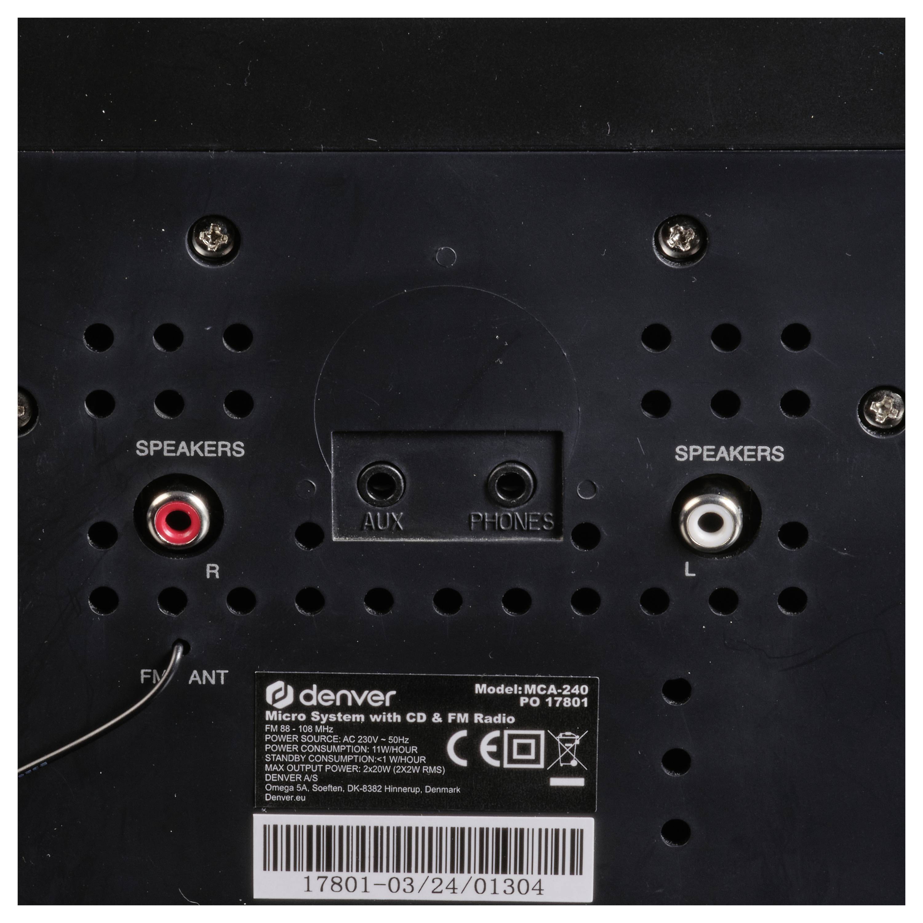 Das Bild zeigt die Rückseite eines Audiogeräts mit Anschlüssen für Lautsprecher, AUX und Kopfhörer. Es gibt ein Etikett mit Modelldetails.