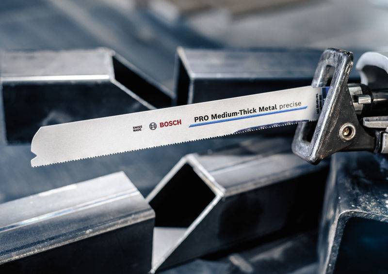 Sägeblatt der Marke Bosch für mitteldickes Metall in Nahaufnahme, neben Metallstücken platziert.