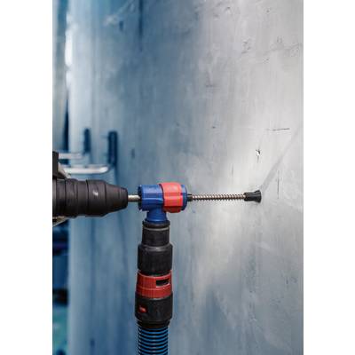 Ein Bohrer wird in eine Betonwand gebohrt, um ein Loch zu machen. Der Bohrer hat einen blauen und roten Griff und ist im Einsatz.