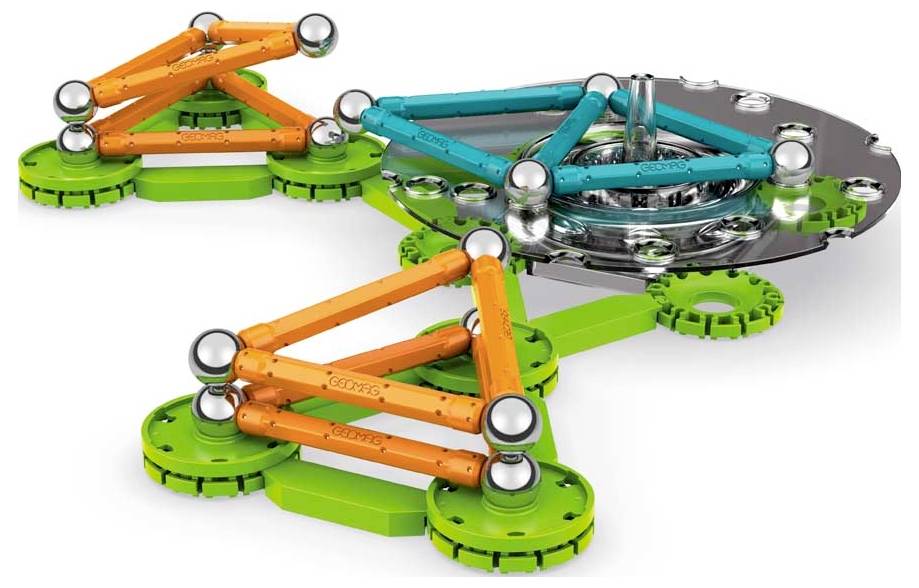 Bunte magnetische Konstruktionsbausteine in Dreiecksformationen auf grünen Basen. Konstruktionsspielzeug auf weißem Hintergrund.