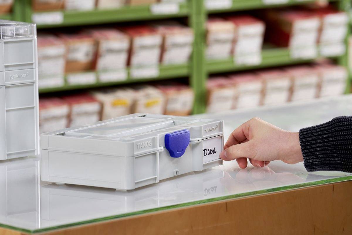 Eine Hand öffnet eine kleine Schublade, die mit "Diode" beschriftet ist, in einem organisierten Lagerbereich für elektronische Bauteile, im Hintergrund sind ähnliche Schachteln zu sehen.