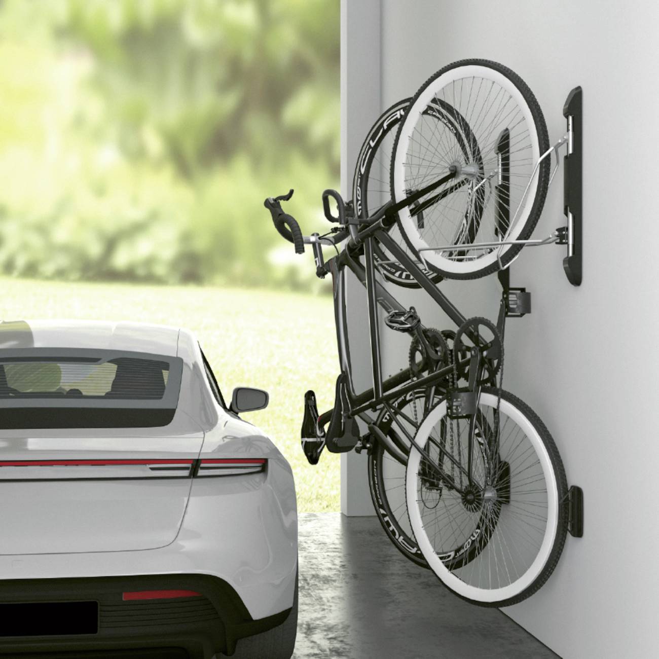 Ein Auto steht in einer Garage neben zwei vertikal an der Wand befestigten Fahrrädern. Im Hintergrund ist Grünfläche zu sehen.