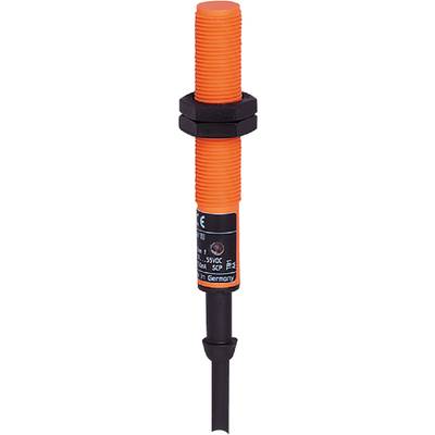 Ein orangefarbenes, zylindrisches Gerät mit schwarzem Etikett, zeigt technische Informationen und Symbole.