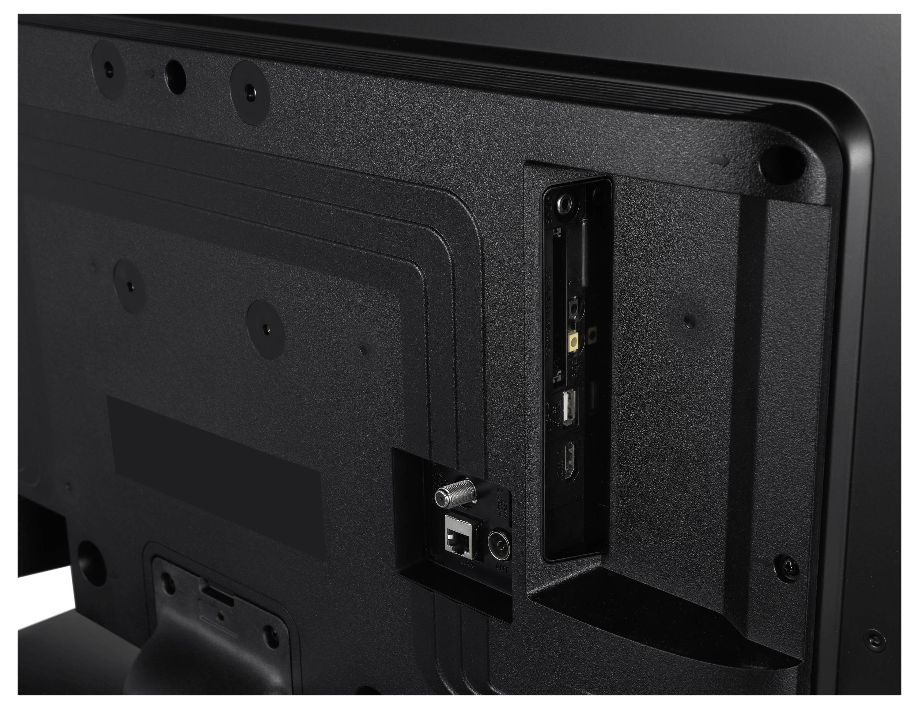 Rückseite eines Fernsehers mit geöffnetem Anschlussfeld. Sichtbare Anschlüsse sind USB, HDMI und Koaxialkabel-Port.