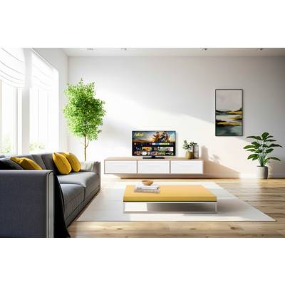 Helles Wohnzimmer mit grauem Sofa, gelbem Tisch, Wand-TV, Pflanzen und Kunstwerk. Moderne Einrichtung mit natürlichem Licht.