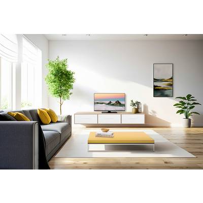 Ein modernes Wohnzimmer mit grauem Sofa, gelbem Couchtisch und einem Fernseher auf einer weißen Konsole. Grünpflanzen dekorieren den Raum.
