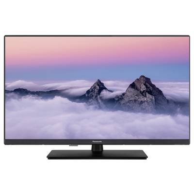 Ein Flachbildfernseher zeigt ein Panorama einer Berglandschaft mit wolkenbedeckten Gipfeln unter einem rosa-blauen Himmel.