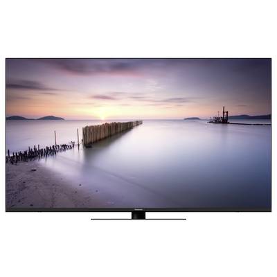Eine friedliche Küstenlandschaft bei Sonnenuntergang, mit ruhigem Wasser und einem langen Holzsteg, der ins Meer ragt.