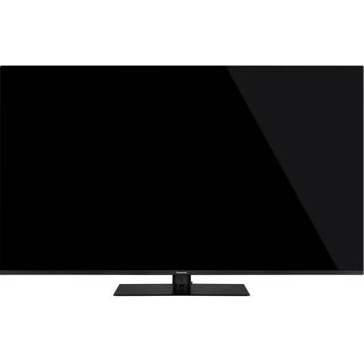 Flacher, schwarzer Fernseher mit großem Bildschirm auf rechteckigem Standfuß. Minimalistisches Design ohne sichtbare Bedienelemente.