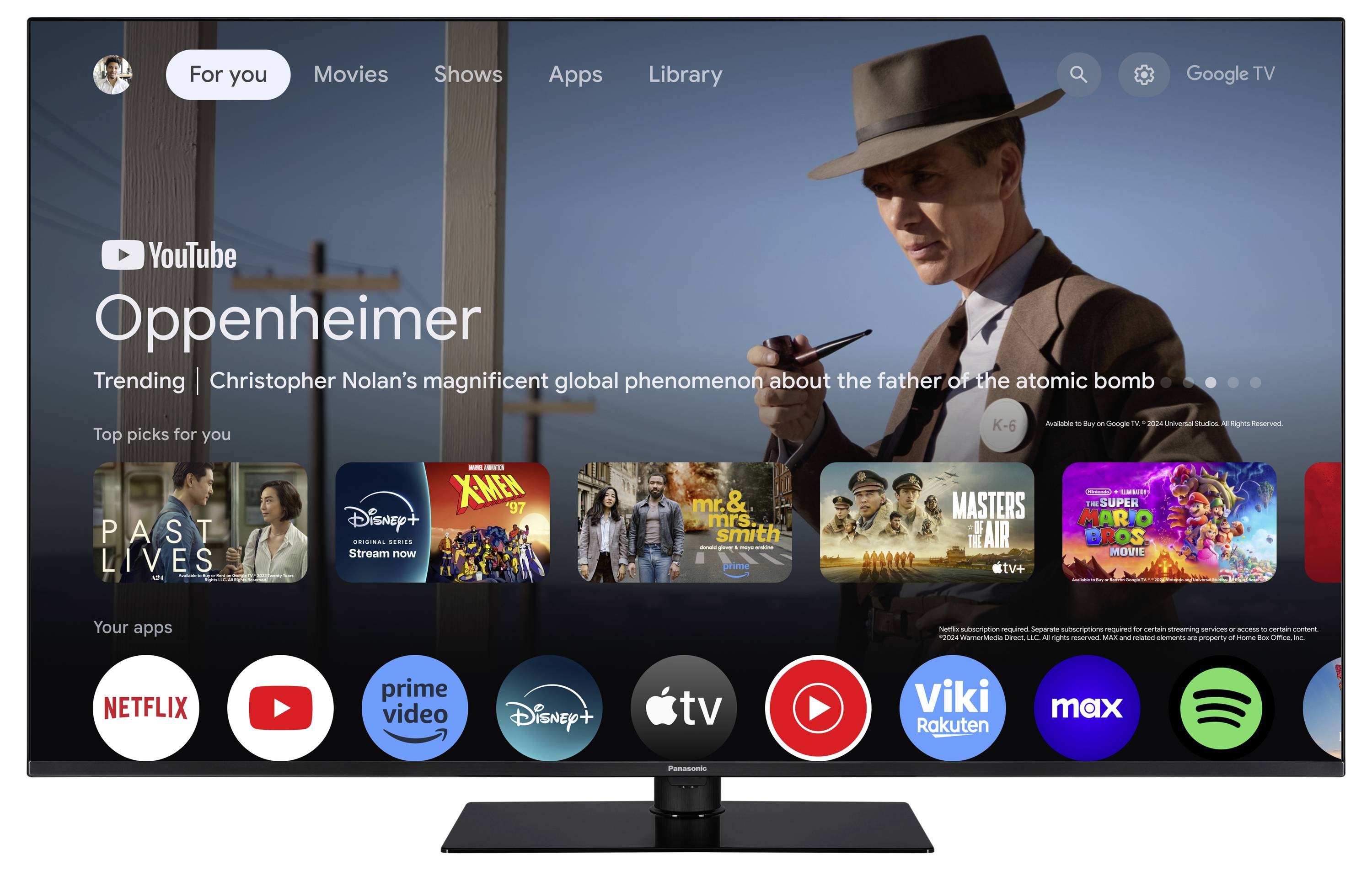 Ein Fernseher zeigt die Benutzeroberfläche von Google TV. 'Oppenheimer' wird vorgeschlagen, umgeben von anderen App-Icons wie Netflix und Disney+.