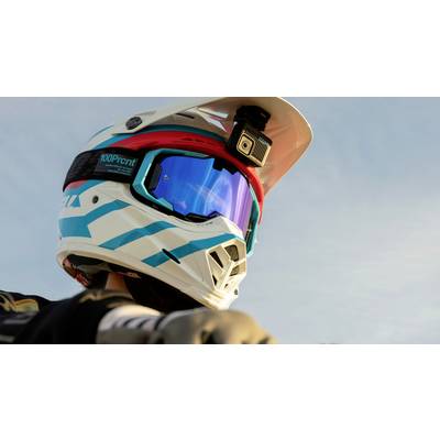 Ein Mountainbiker trägt einen weißen Helm mit blauen und roten Akzenten, ausgestattet mit einer Kamera, während er in den Himmel blickt.