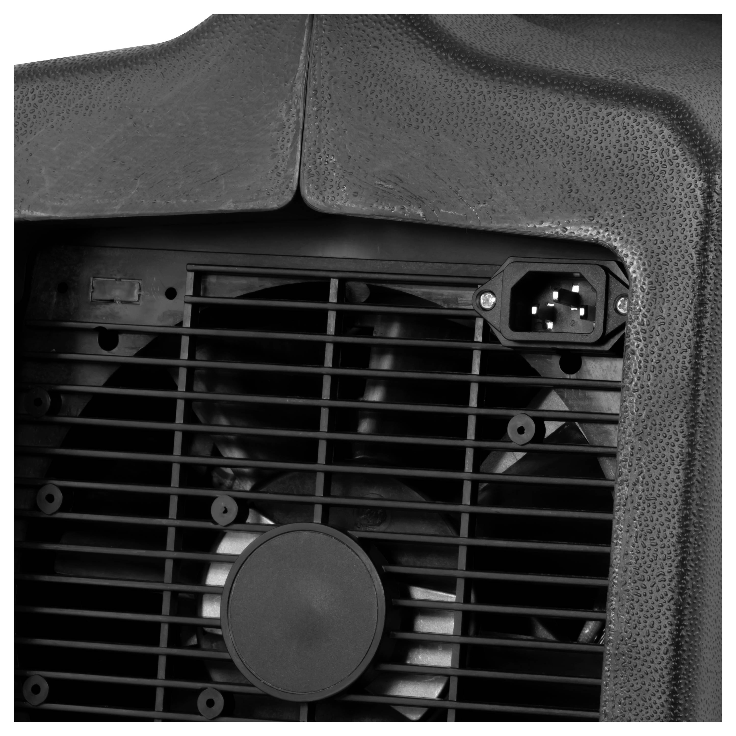 Nahaufnahme eines schwarzen Kühlventilators hinter einem Gitter, mit einem sichtbaren Stromstecker oben rechts.